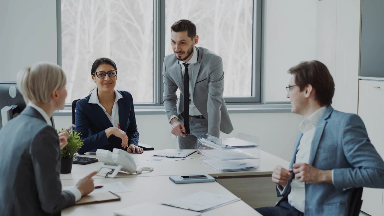 A consultant leading a discussion with executives around a meeting table