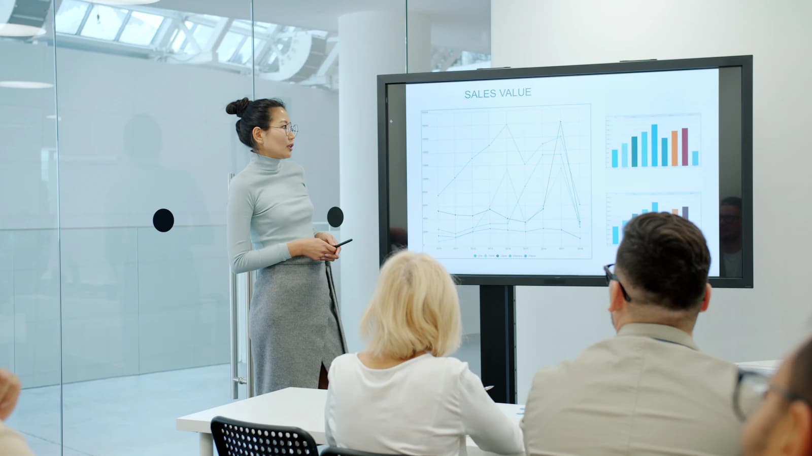 A presenter walking colleagues through a chart on a large screen