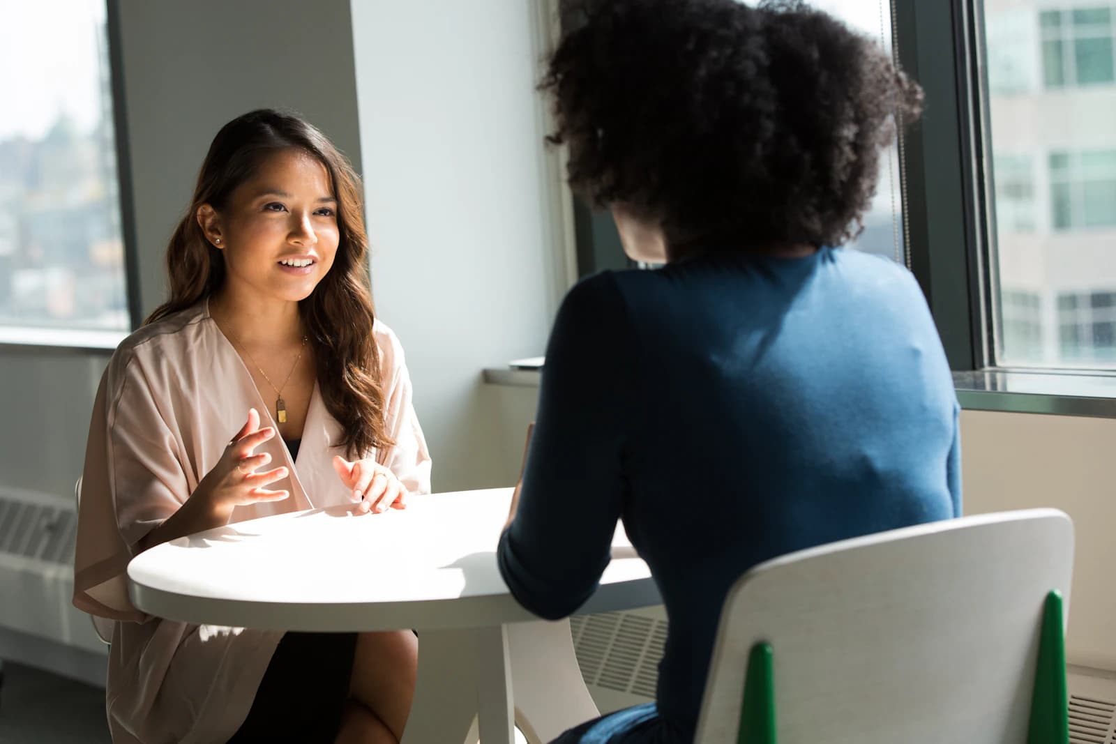 A researcher interviewing a participant at a table