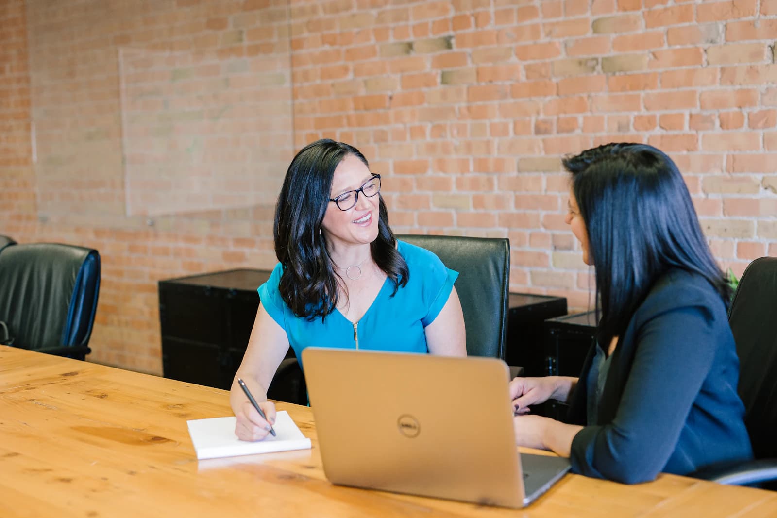 Two colleagues in conversation over a laptop