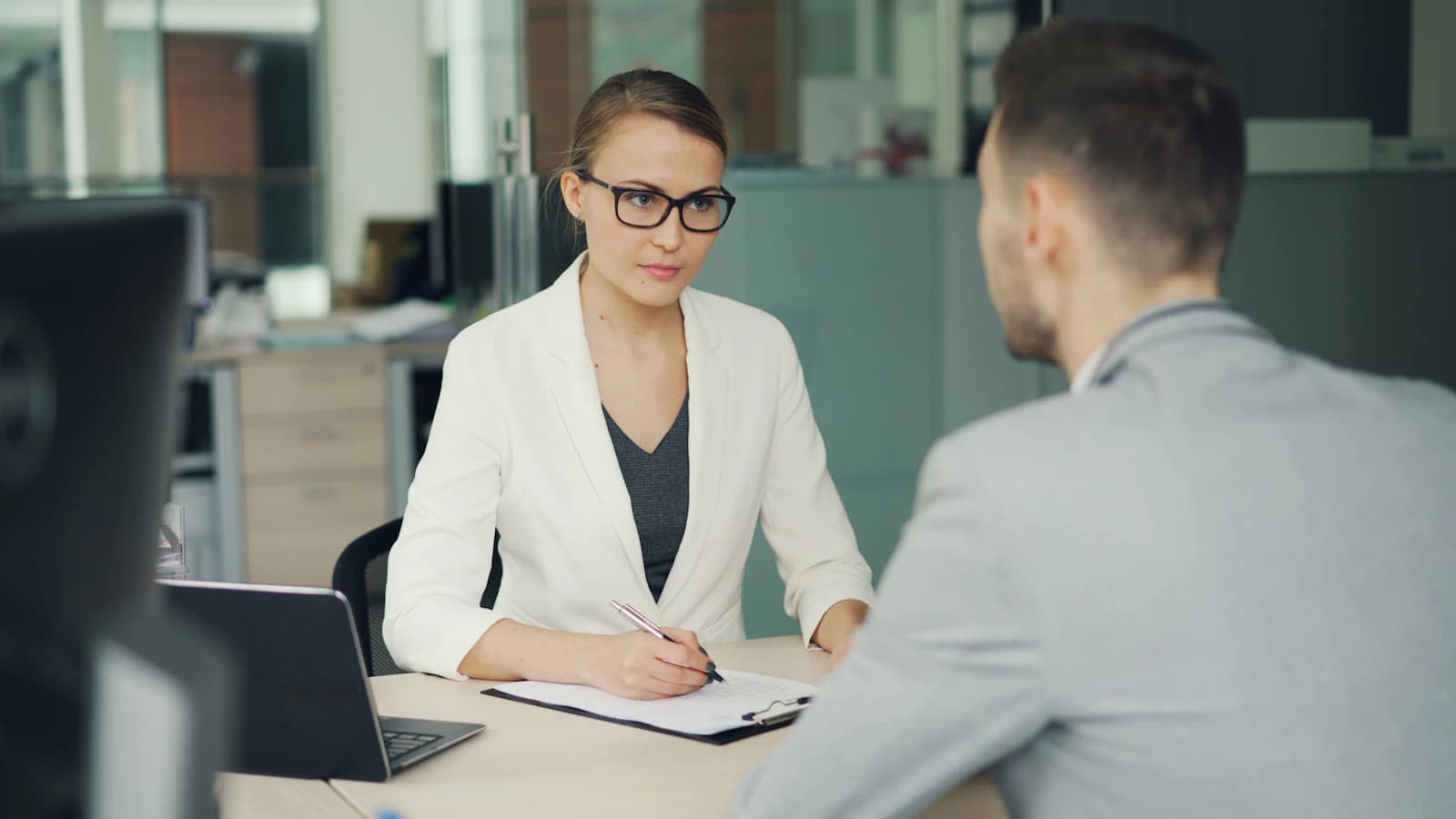 A consultant interviewing a manager across a desk