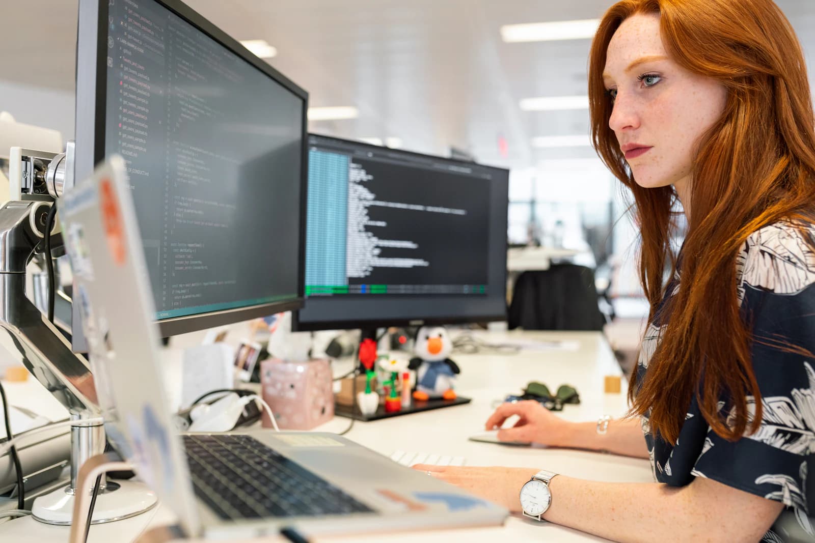 A data engineer working at two monitors