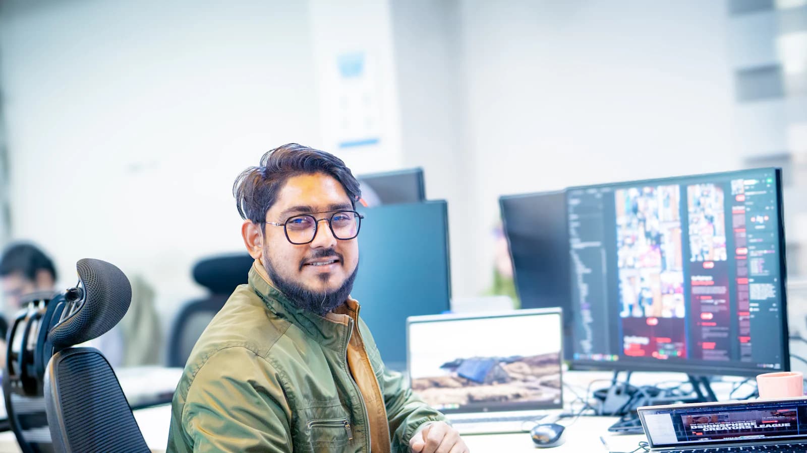 An engineer at his desk in front of several monitors