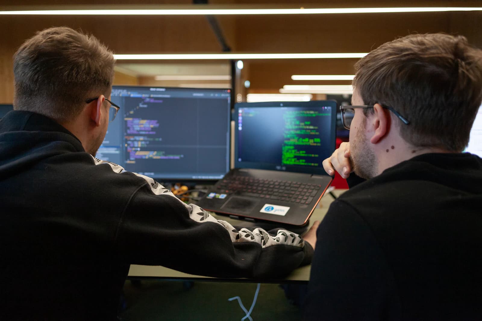 Two engineers checking results on a laptop together