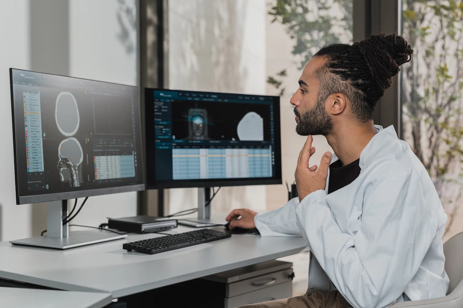 An analyst studying image data across two monitors