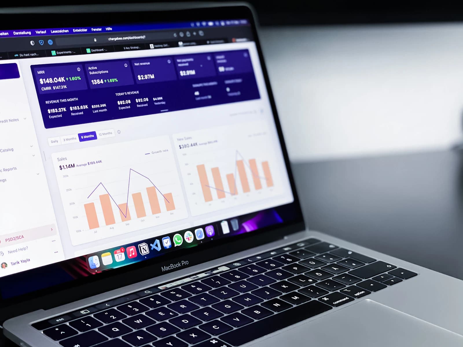 A laptop showing a sales dashboard with bar charts