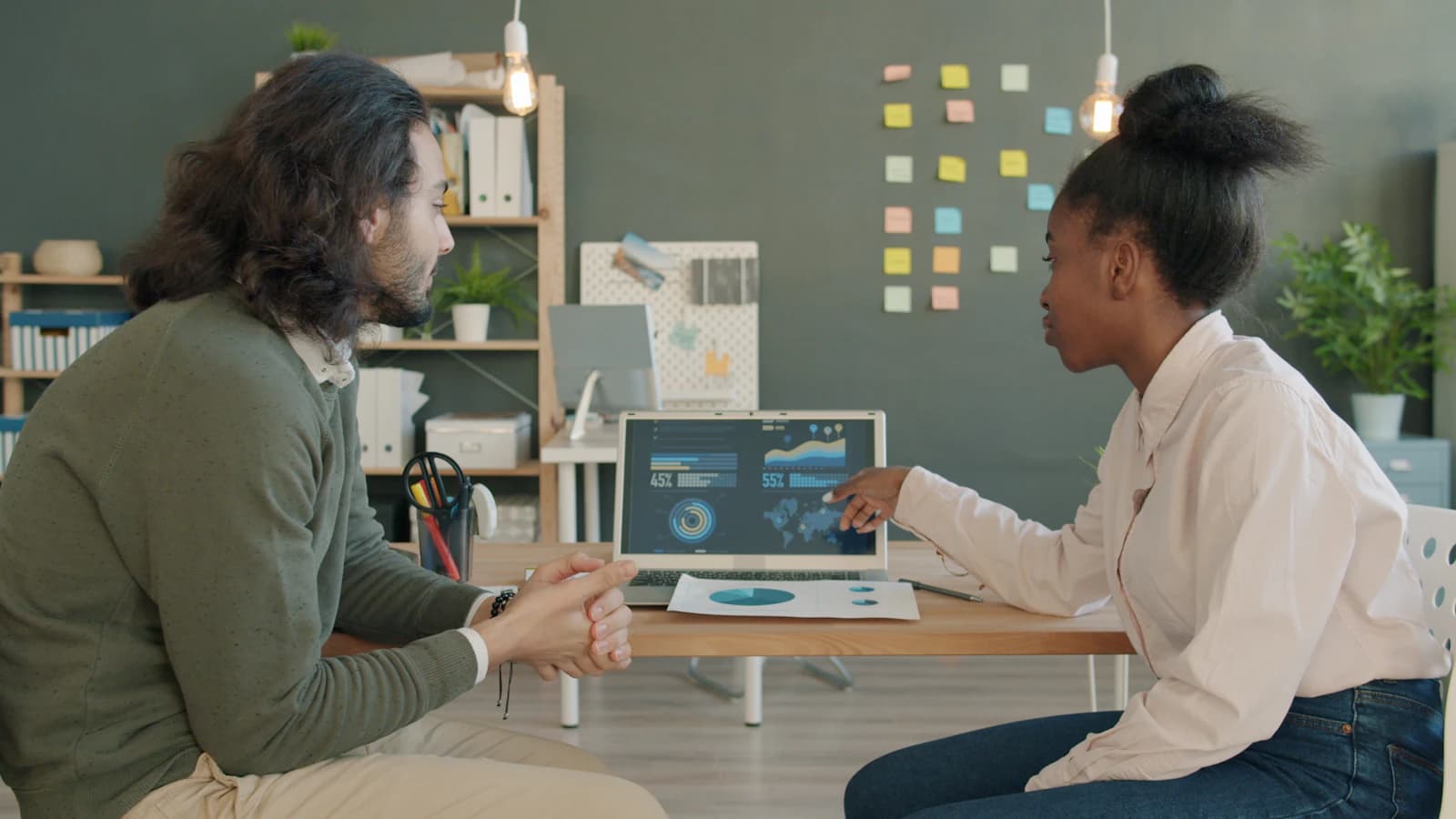 Two colleagues reviewing a dashboard on a screen