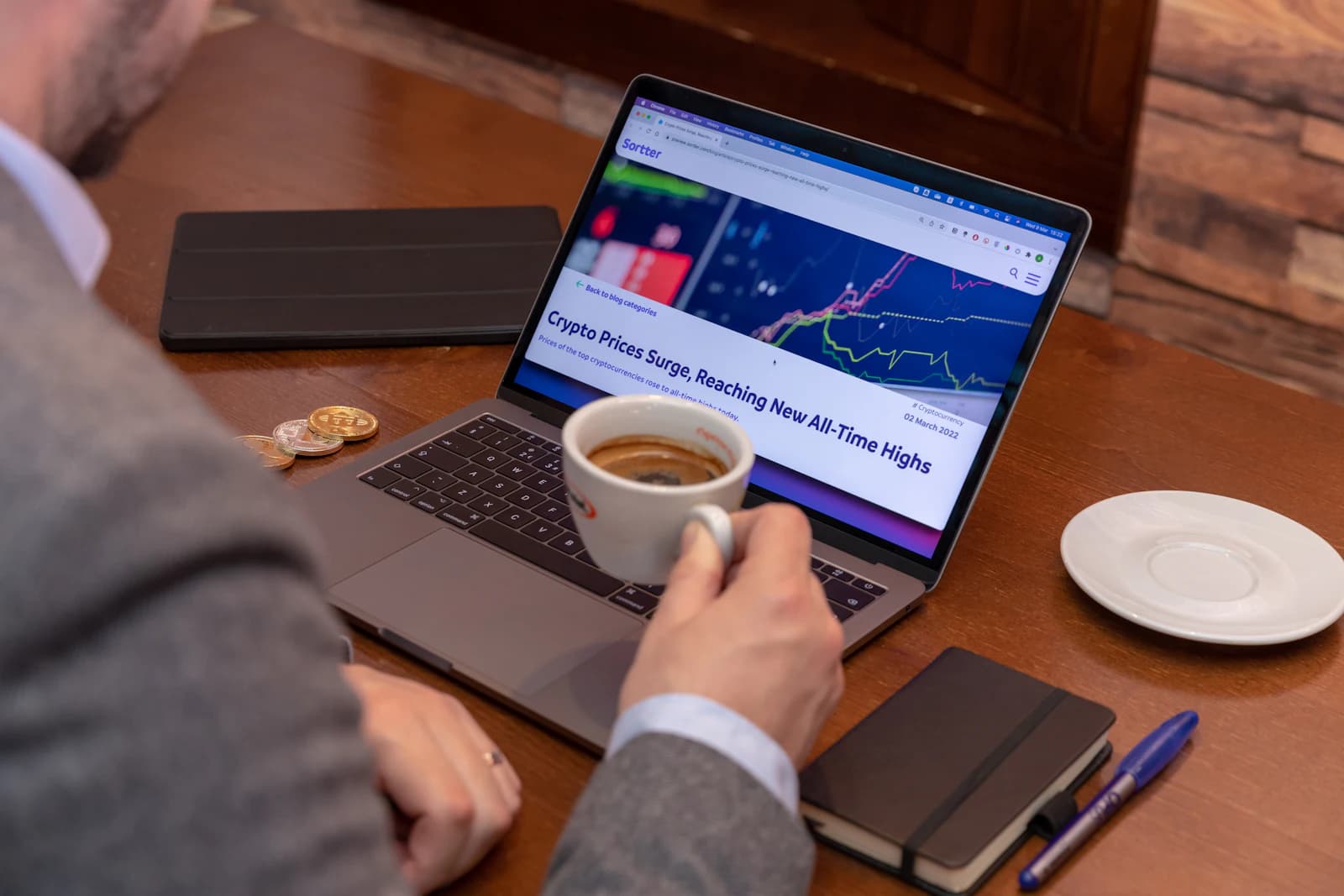 A laptop showing a dashboard beside a cup of coffee