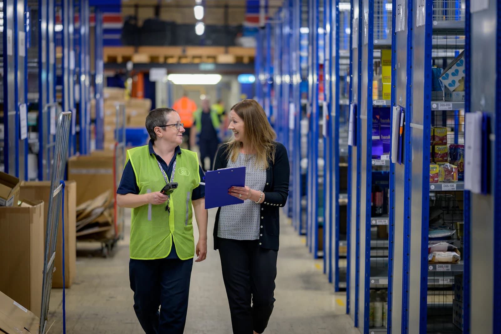 Warehouse staff checking stock along the aisles