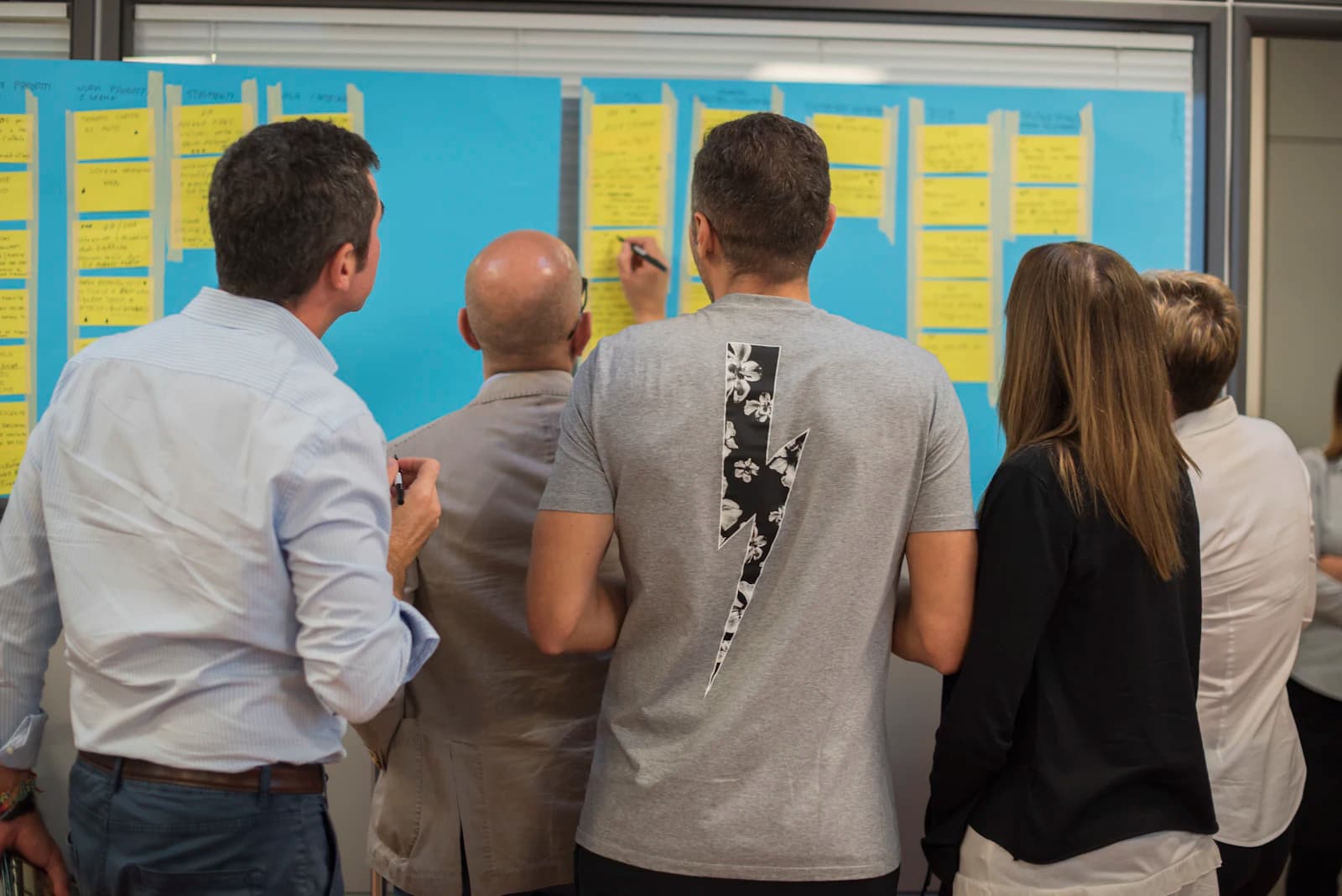 A team arranging notes on a wall during a discovery workshop