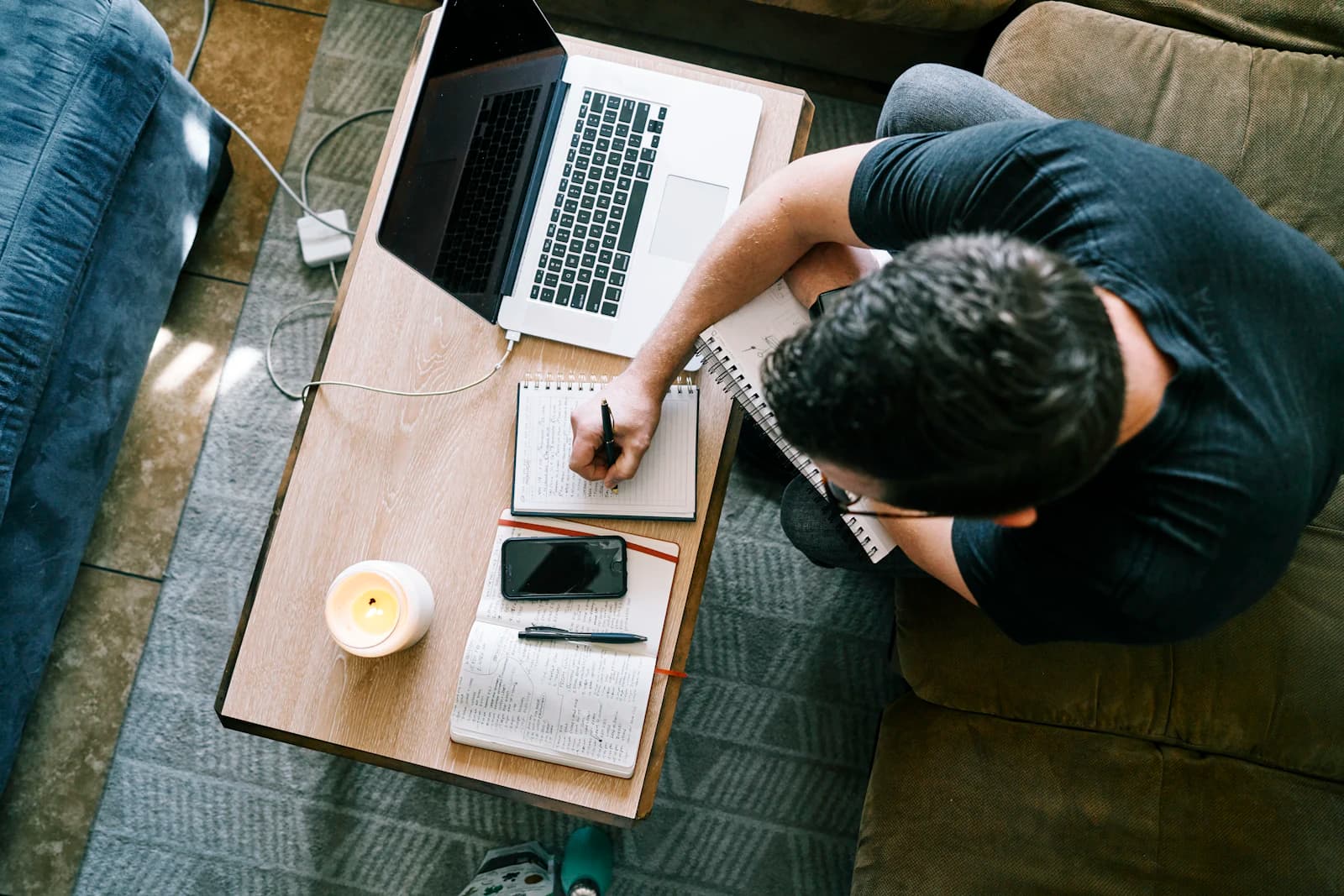 A reviewer taking notes beside a laptop