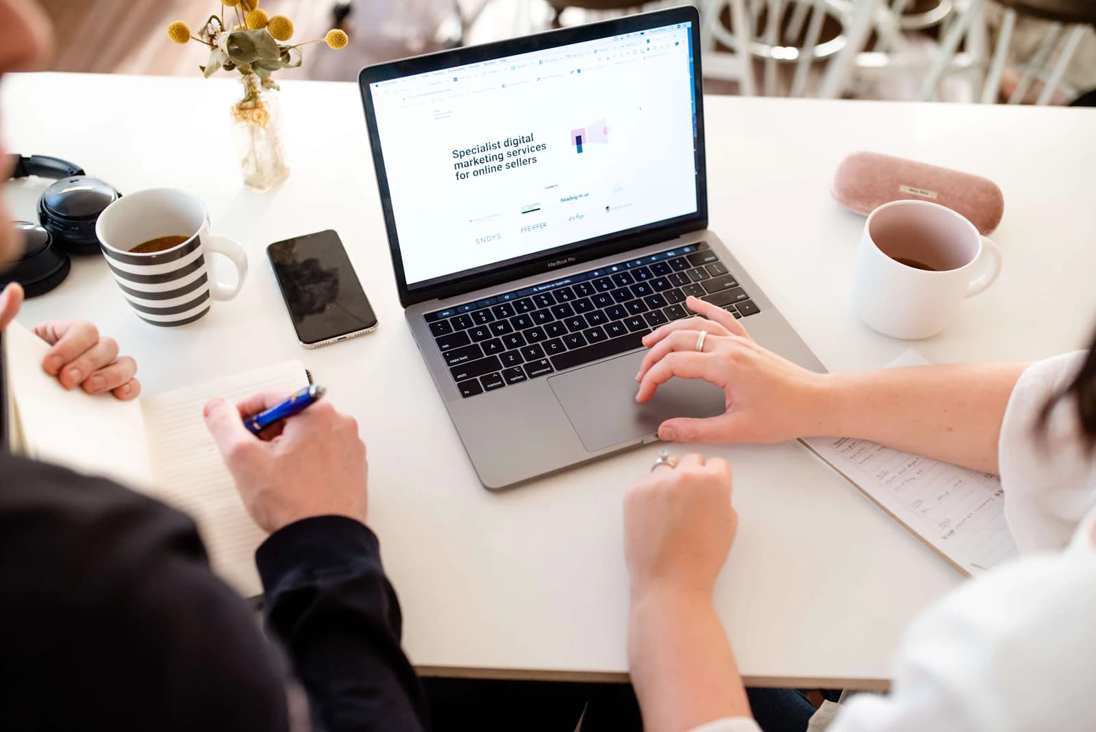 Reviewing a website on a laptop with notes on the table